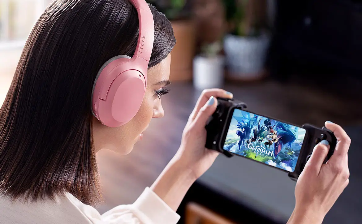 woman playing mobile game while wearing Quartz Pink Razer Opus X wireless ANC headset