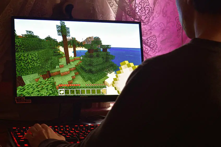man playing Minecraft on a PC computer