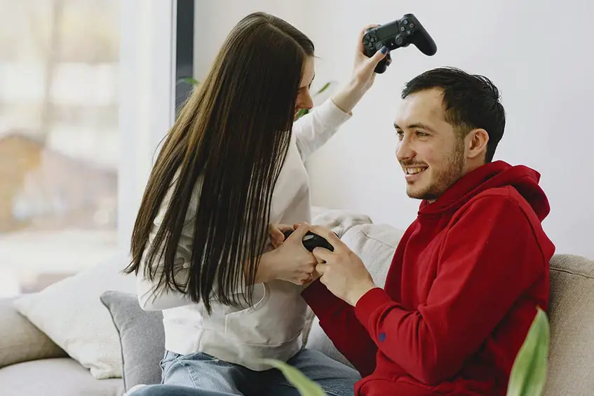 man woman couple gaming fighting over controller
