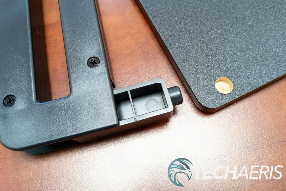 The plastic legs for the StarTech Monitor Riser Stand with Wireless Charging Pad fasten into a hole on the underside of the working surface