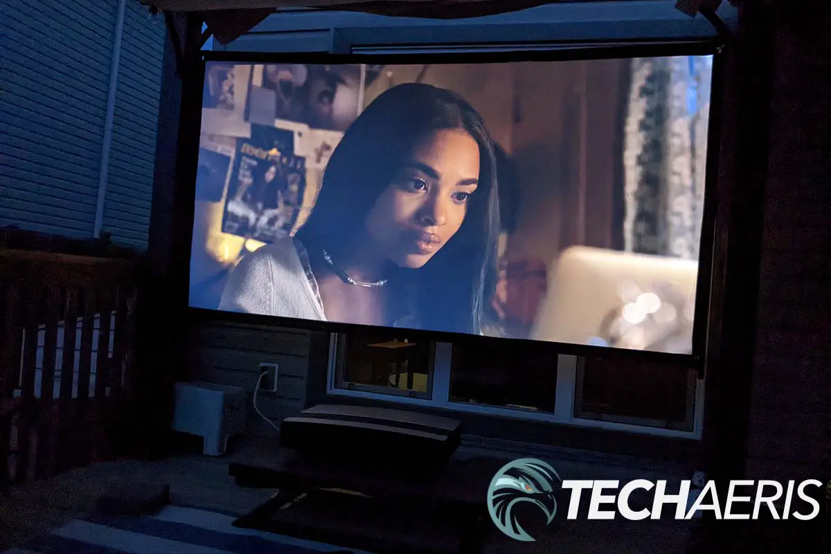 The XGIMI AURA 4K UST projector in use outside with a portable screen