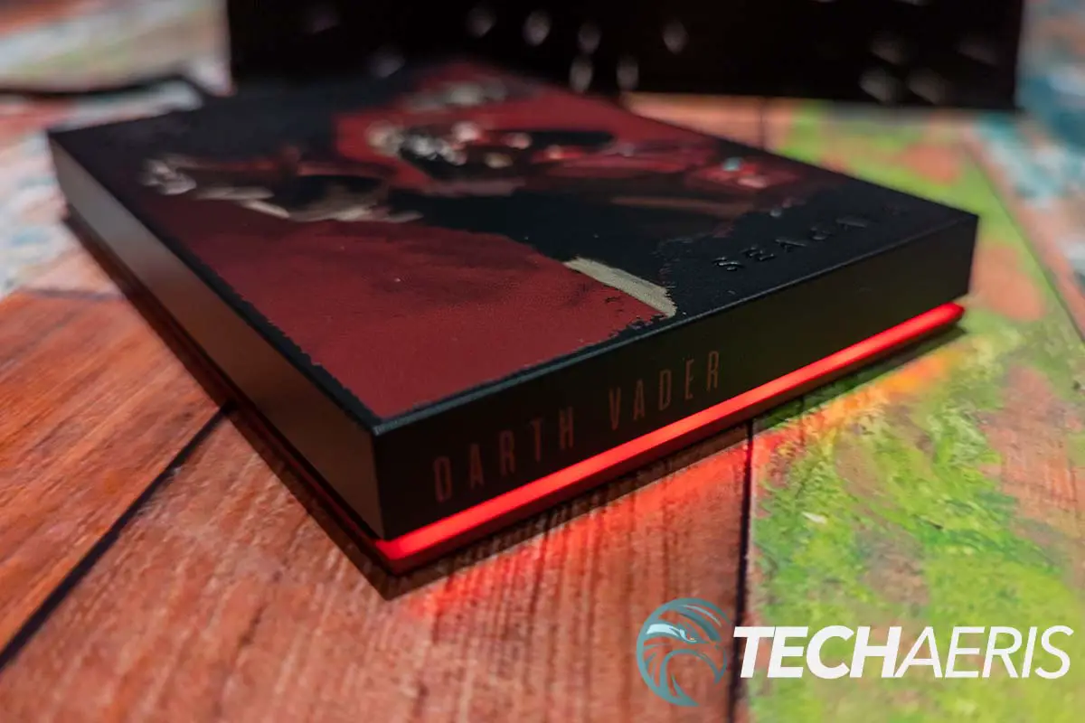 The front edge of the Darth Vader-themed Seagate Gaming FireCuda Star Wars-inspired HDD with the RGB LED on (default red colour shown).
