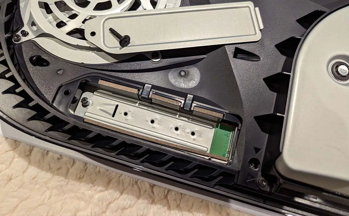 An opened PlayStation 5 gaming console showing the empty SSD expansion slot