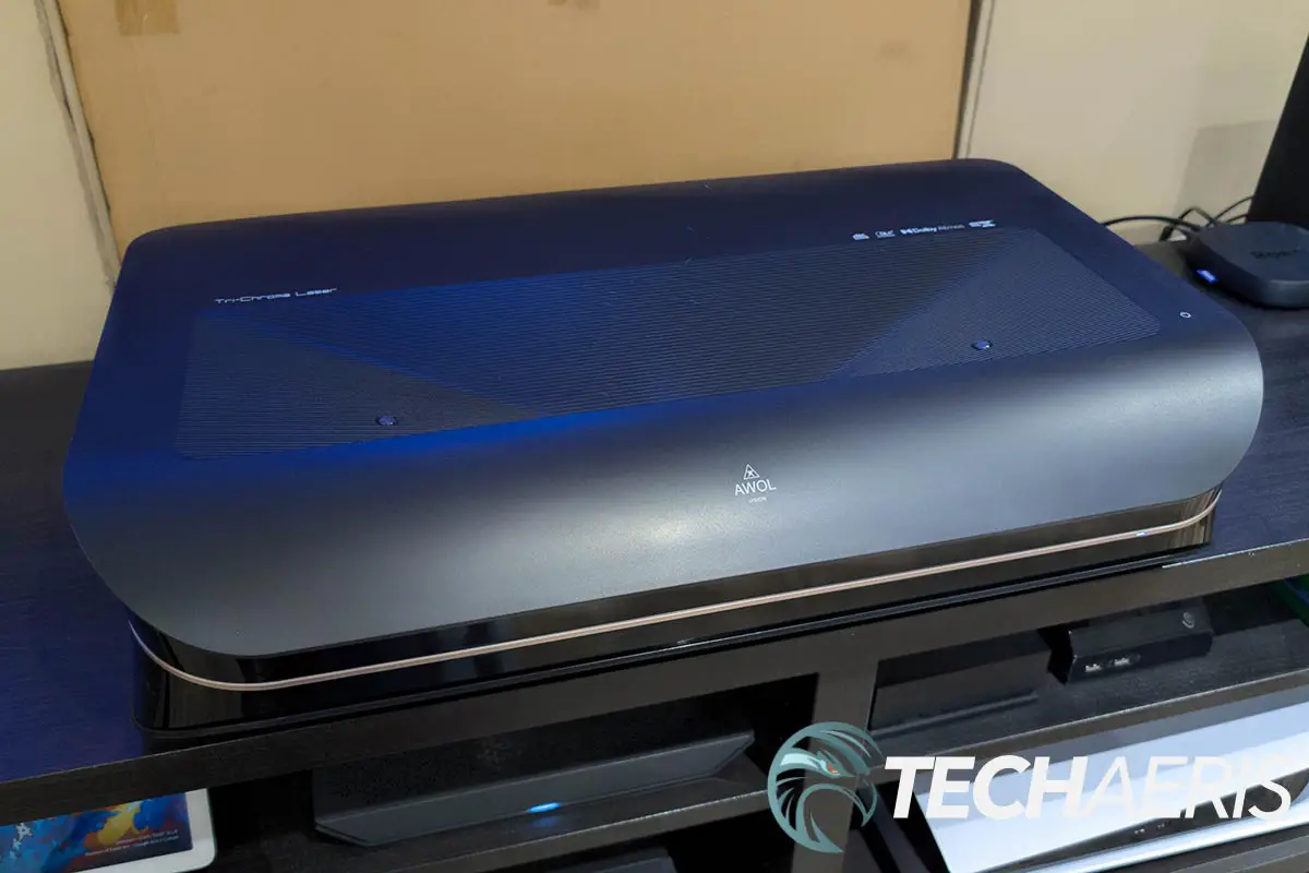 The AWOL Vision LTV-3000 Pro UST 4K Tri-Chroma Laser Projector set up on a cabinet